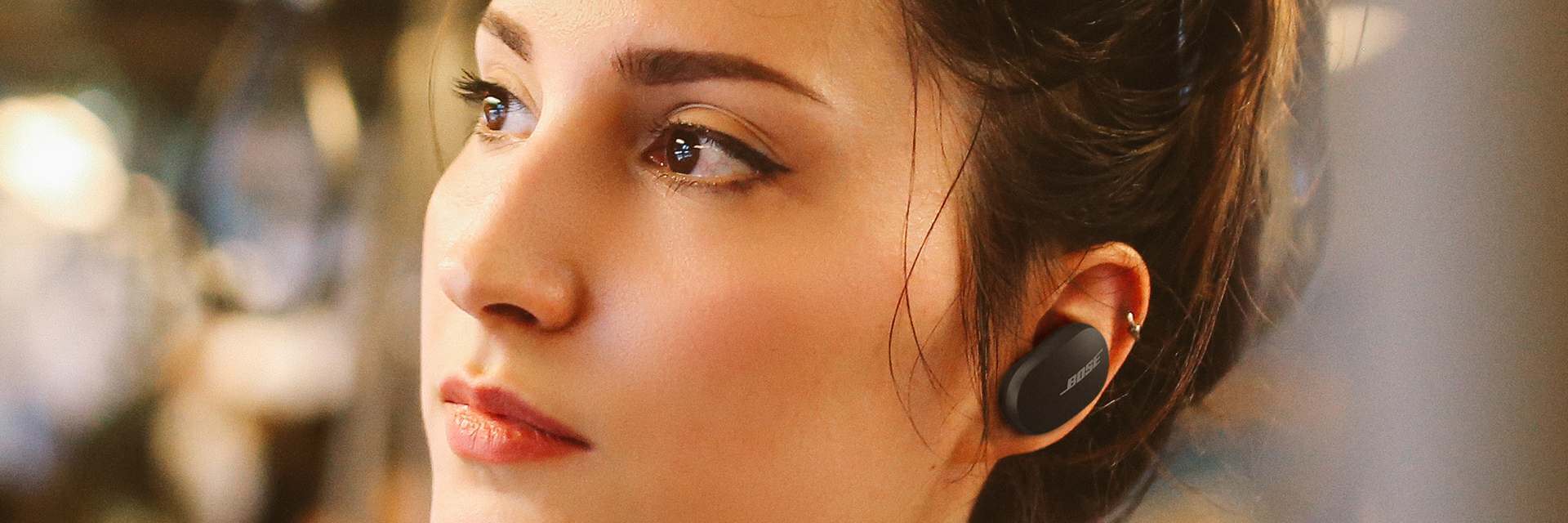 side view of a woman wearing an earbud